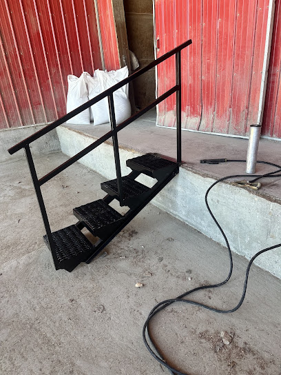 Custom fabricated steel stairs with handrail beside a building